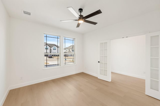 spare room featuring light wood-style floors, visible vents, and french doors