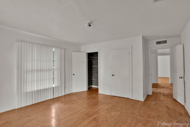 unfurnished bedroom featuring light hardwood / wood-style flooring and a textured ceiling