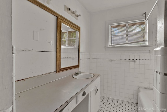 bathroom featuring a wealth of natural light, vanity, and tile walls