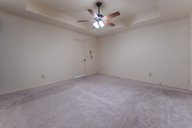 carpeted spare room with ceiling fan, a raised ceiling, and crown molding