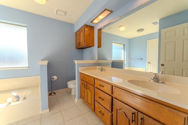 bathroom featuring tile patterned floors, a tub to relax in, vanity, and toilet