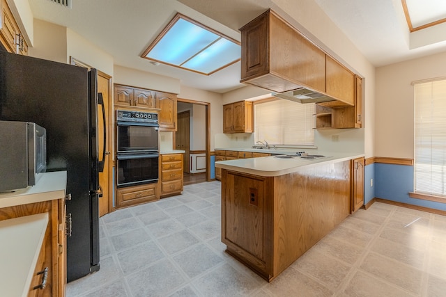 kitchen featuring kitchen peninsula, sink, and double oven