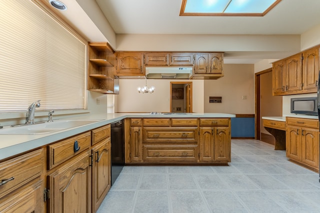 kitchen featuring kitchen peninsula, a skylight, sink, and hanging light fixtures