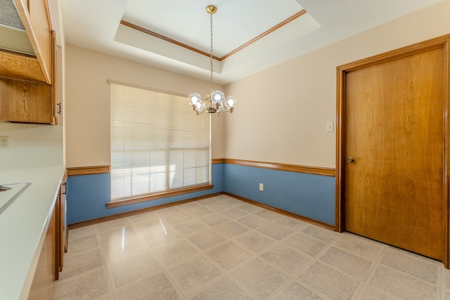 unfurnished dining area featuring a raised ceiling and a chandelier