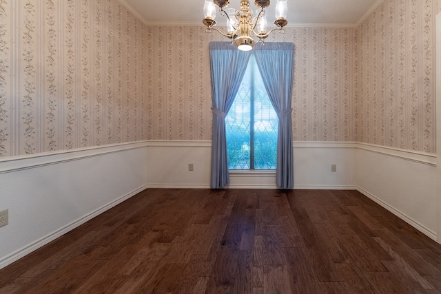 spare room with hardwood / wood-style floors, an inviting chandelier, and ornamental molding