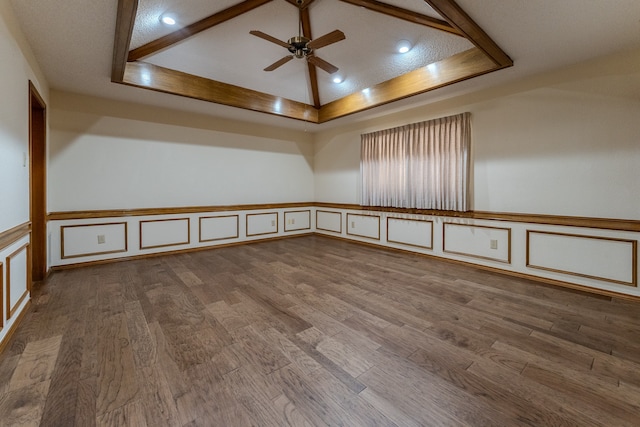 unfurnished room featuring a tray ceiling, ceiling fan, a textured ceiling, and hardwood / wood-style flooring