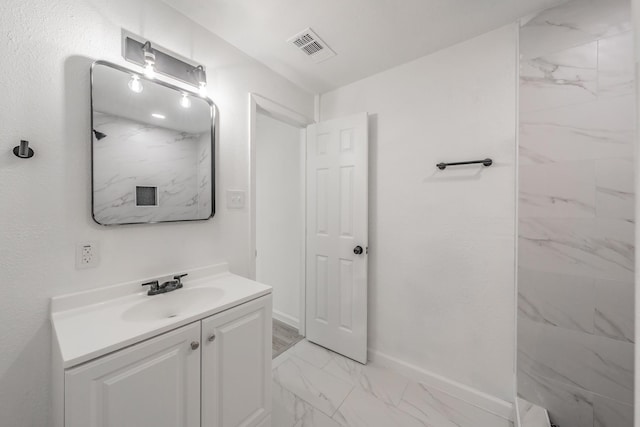 bathroom with vanity and tiled shower