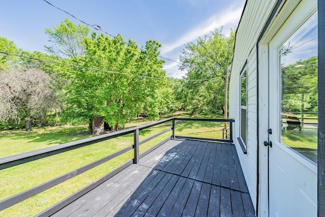 wooden terrace featuring a lawn