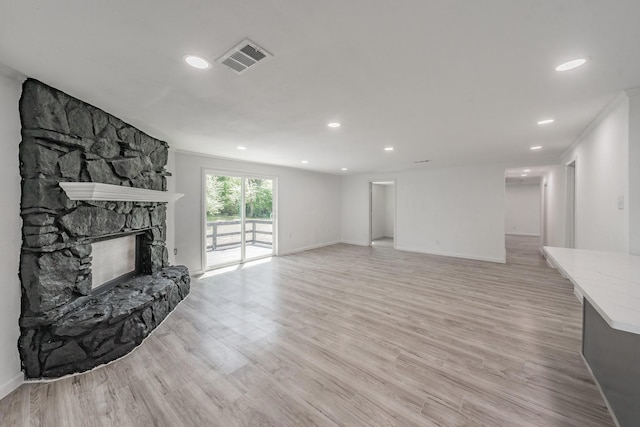 unfurnished living room with ornamental molding, a fireplace, and light hardwood / wood-style floors