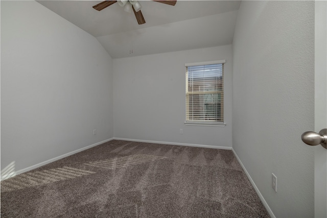 empty room featuring ceiling fan, lofted ceiling, and dark carpet