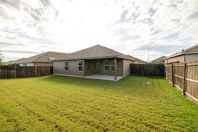 rear view of house with a patio area and a yard