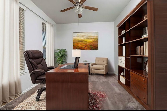 home office with dark carpet and ceiling fan