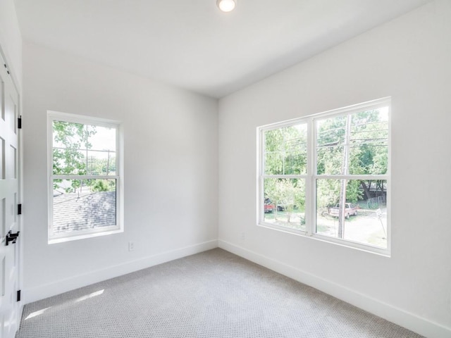 carpeted spare room featuring plenty of natural light