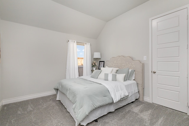 bedroom with carpet floors and vaulted ceiling