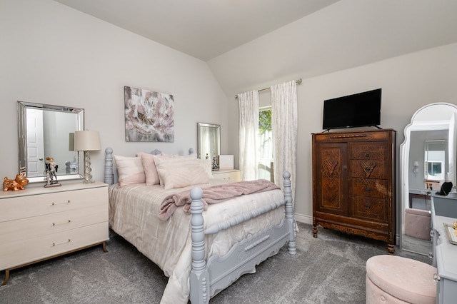 bedroom with dark colored carpet and vaulted ceiling