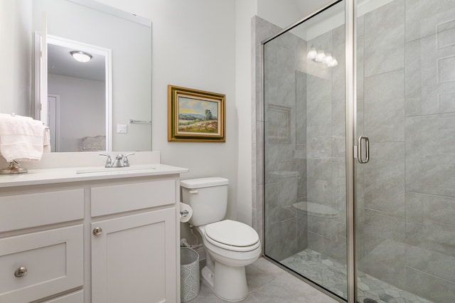 bathroom with tile patterned floors, toilet, vanity, and walk in shower