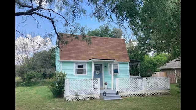 view of front of property featuring a deck and a front yard