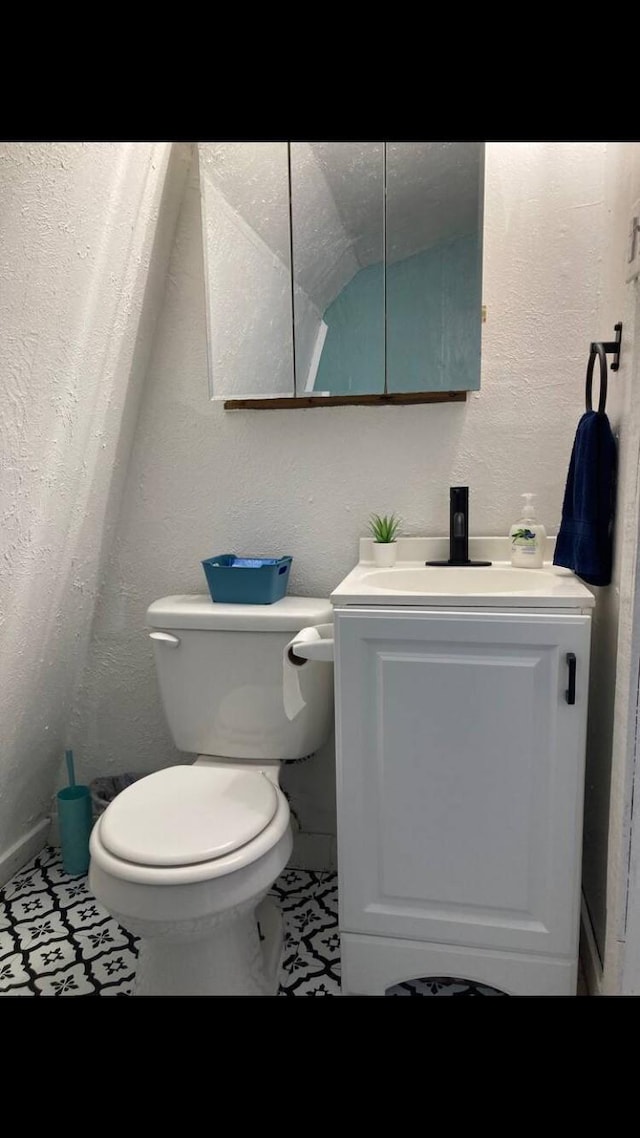 bathroom with tile patterned flooring, vanity, and toilet