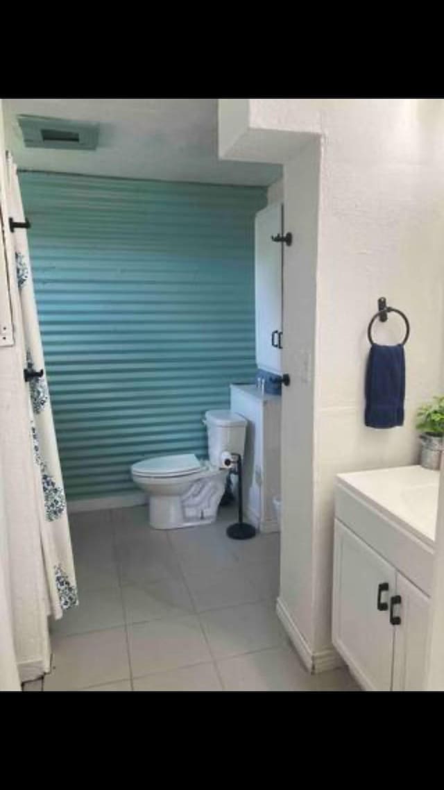 bathroom featuring tile patterned flooring, vanity, and toilet