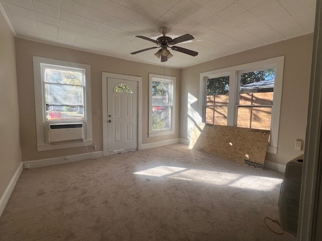 interior space with ornamental molding, light colored carpet, ceiling fan, and cooling unit