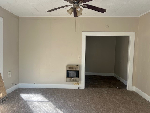 unfurnished room featuring heating unit, crown molding, ceiling fan, and dark colored carpet