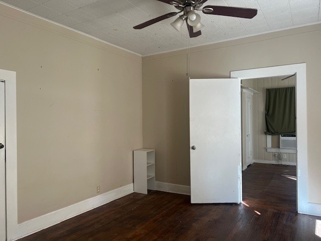 empty room with ornamental molding, ceiling fan, and dark hardwood / wood-style flooring