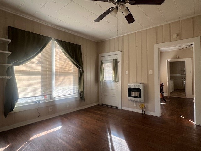 unfurnished living room featuring heating unit, ornamental molding, dark hardwood / wood-style floors, and ceiling fan