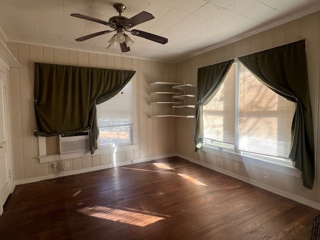 empty room featuring hardwood / wood-style flooring, crown molding, and ceiling fan