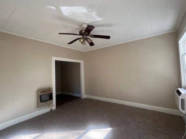 empty room with crown molding, ceiling fan, dark carpet, and heating unit