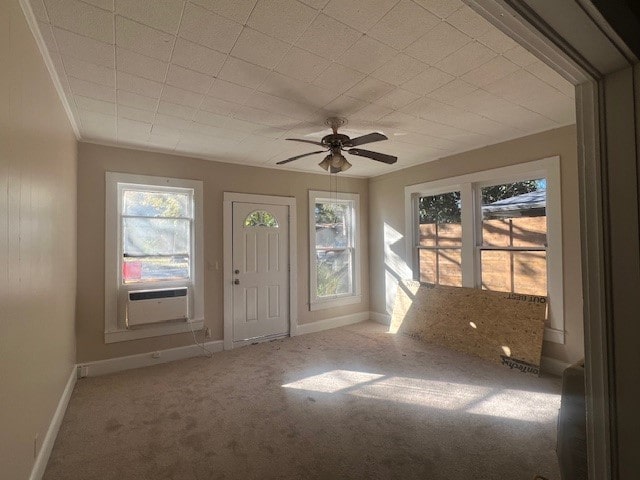 foyer entrance with cooling unit, crown molding, light colored carpet, and ceiling fan