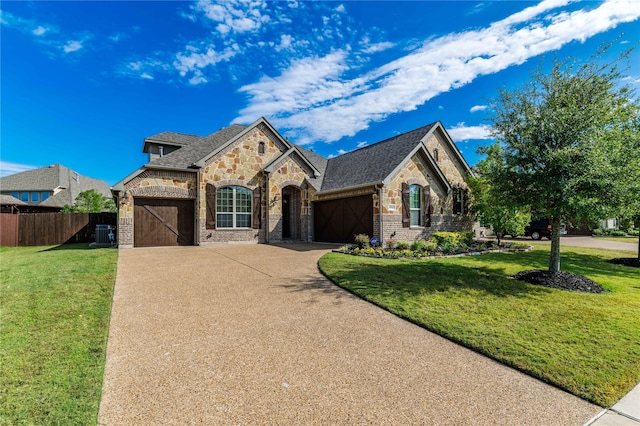 view of front facade with central AC, a front lawn, and a garage