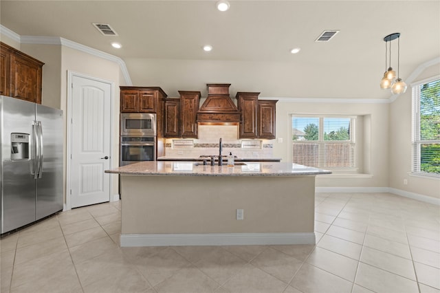 kitchen featuring custom exhaust hood, a kitchen island with sink, appliances with stainless steel finishes, tasteful backsplash, and light stone counters