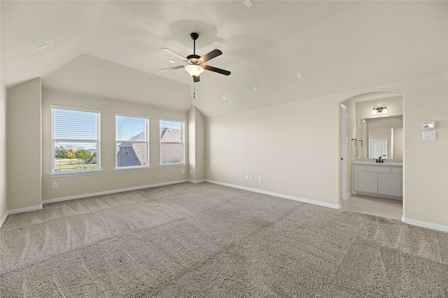 interior space featuring light colored carpet, vaulted ceiling, ceiling fan, and sink