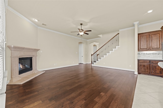 unfurnished living room with light hardwood / wood-style flooring, ceiling fan, and crown molding