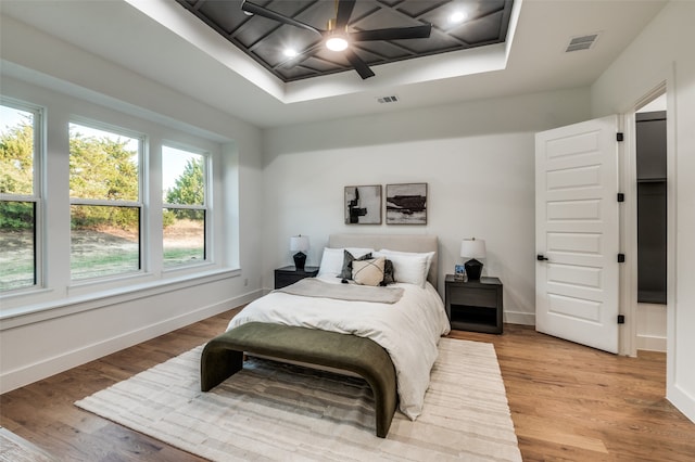 bedroom featuring multiple windows, ceiling fan, and light hardwood / wood-style flooring