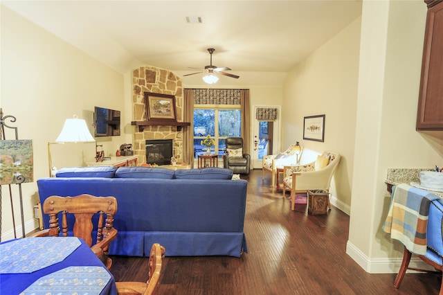 living room with wood-type flooring and a stone fireplace