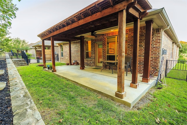 back of house featuring ceiling fan, a yard, and a patio