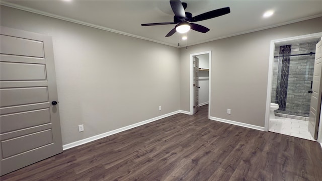 unfurnished bedroom featuring a walk in closet, ensuite bath, dark hardwood / wood-style flooring, and crown molding