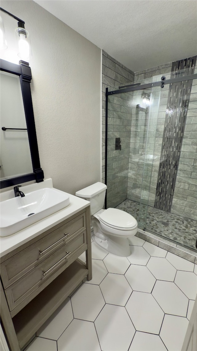 bathroom featuring walk in shower, toilet, vanity, and tile patterned floors