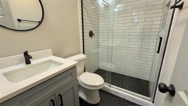 bathroom with an enclosed shower, vanity, tile patterned floors, and toilet