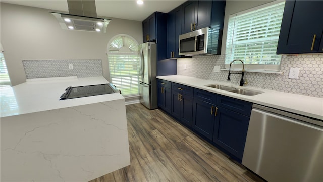 kitchen with a wealth of natural light, appliances with stainless steel finishes, sink, and backsplash