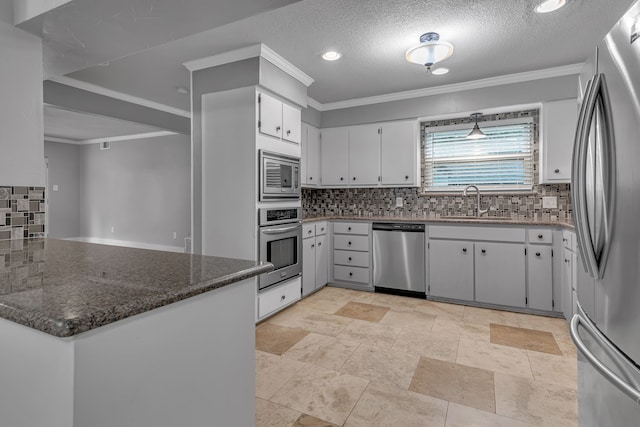 kitchen featuring stainless steel appliances, ornamental molding, dark stone counters, white cabinets, and decorative backsplash