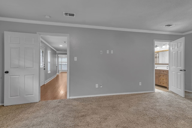 unfurnished room with light hardwood / wood-style floors and crown molding