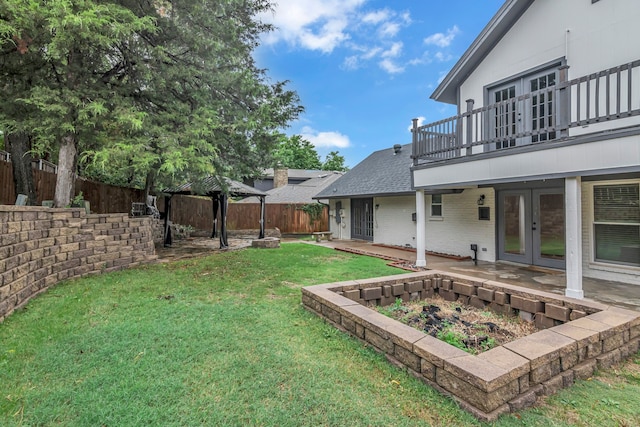 view of yard with a patio area, french doors, a gazebo, and a balcony