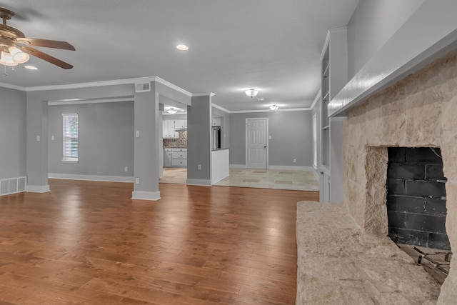 unfurnished living room featuring a premium fireplace, hardwood / wood-style flooring, and crown molding