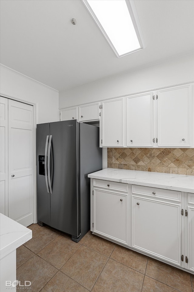 kitchen featuring white cabinetry, stainless steel fridge with ice dispenser, and backsplash