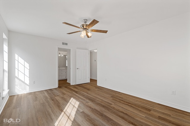 spare room with a wealth of natural light, wood-type flooring, and ceiling fan