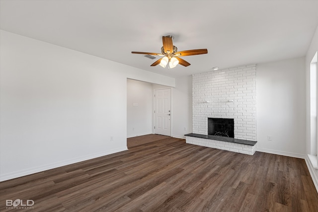 unfurnished living room featuring a fireplace, dark wood-type flooring, and ceiling fan