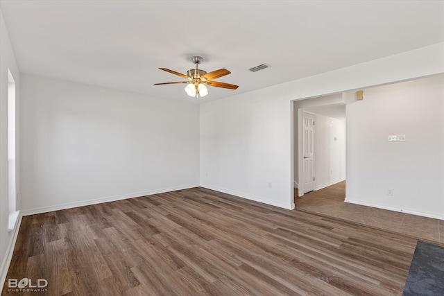 empty room with dark wood-type flooring and ceiling fan