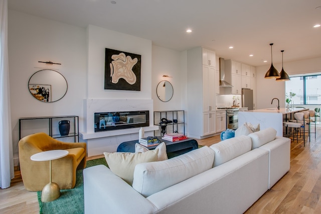 living room with light wood-type flooring and sink